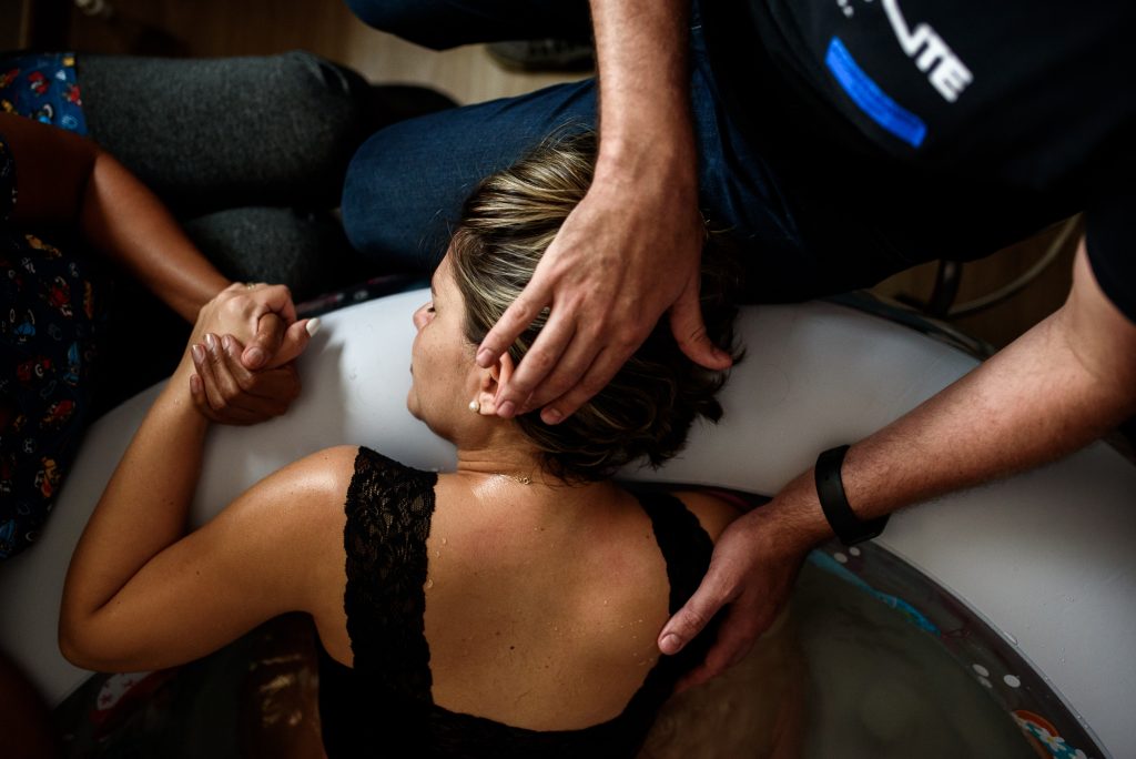 mulher em trabalho de parto sendo assistida por equipe multidisciplinar; foto com direitos autorais pertencentes à fotógrafa monique olive