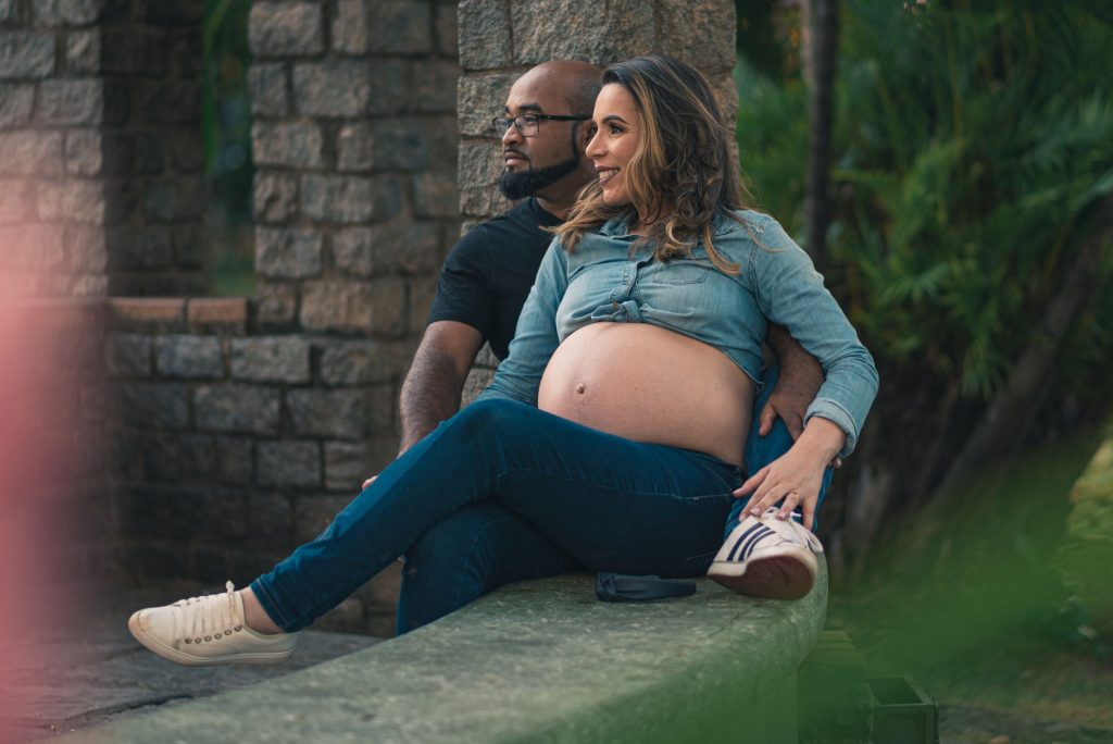 Pregnant woman and partner relaxing outside, showcasing love and anticipation.